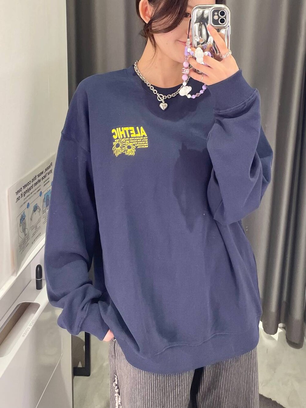 ブラック系のデニムパンツ、ブルー系のスウェット、シルバー系のネックレスを着用したレディースの秋コーディネートの4枚目の写真