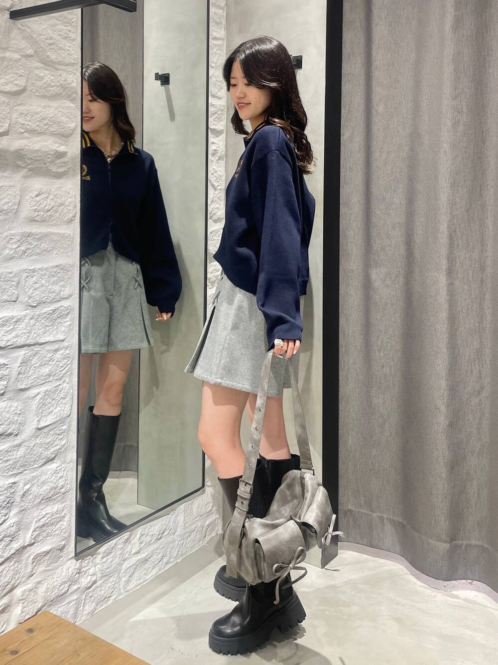 グレー系のショルダーバッグ、ブラック系のその他パンツ、ブラック系のブーツを着用したレディースの秋コーディネートの4枚目の写真