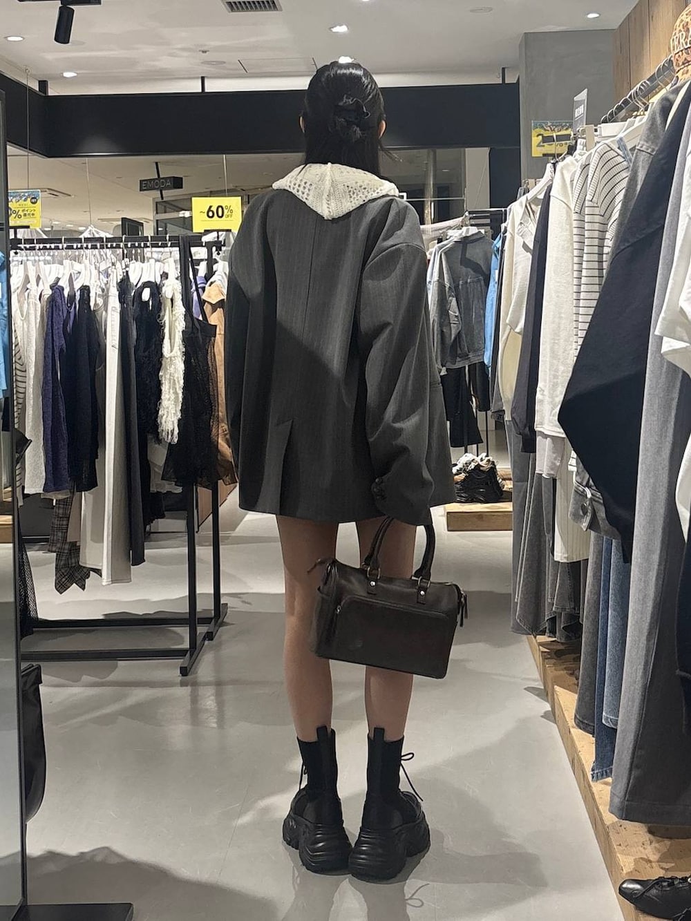 ブラック系のブーツ、ホワイト系のパーカー、グレー系のショルダーバッグを着用したレディースの春コーディネートの4枚目の写真