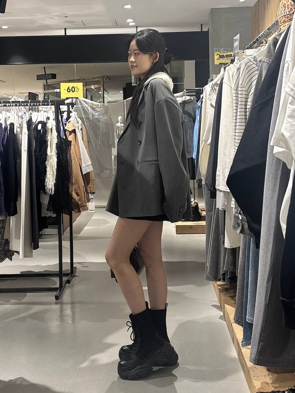 ブラック系のブーツ、ホワイト系のパーカー、グレー系のショルダーバッグを着用したレディースの春コーディネートの3枚目の写真