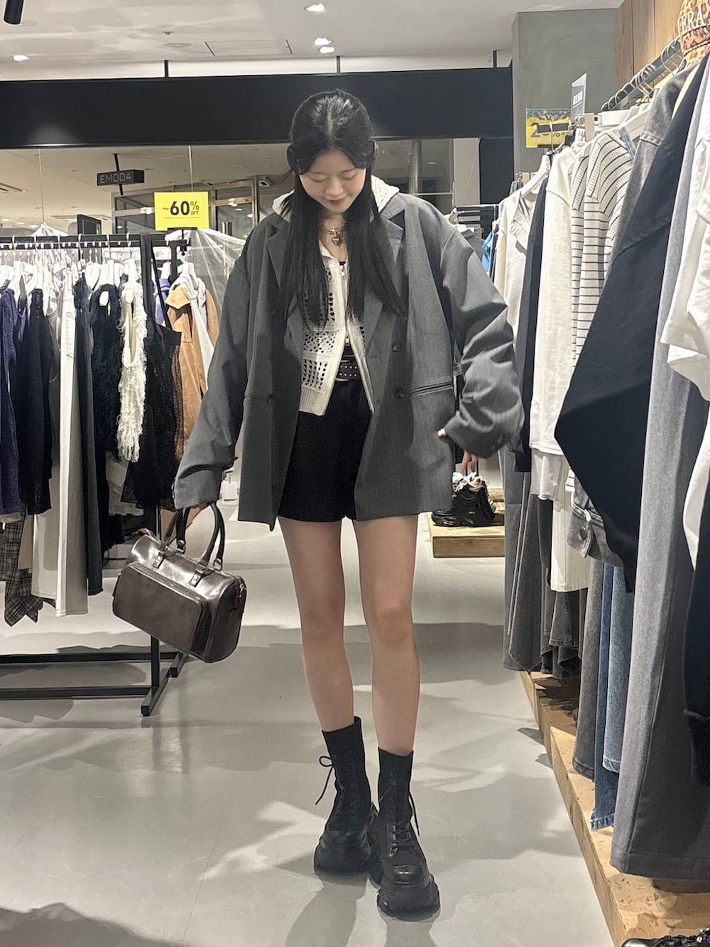 ブラック系のブーツ、ホワイト系のパーカー、グレー系のショルダーバッグを着用したレディースの春コーディネートの6枚目の写真