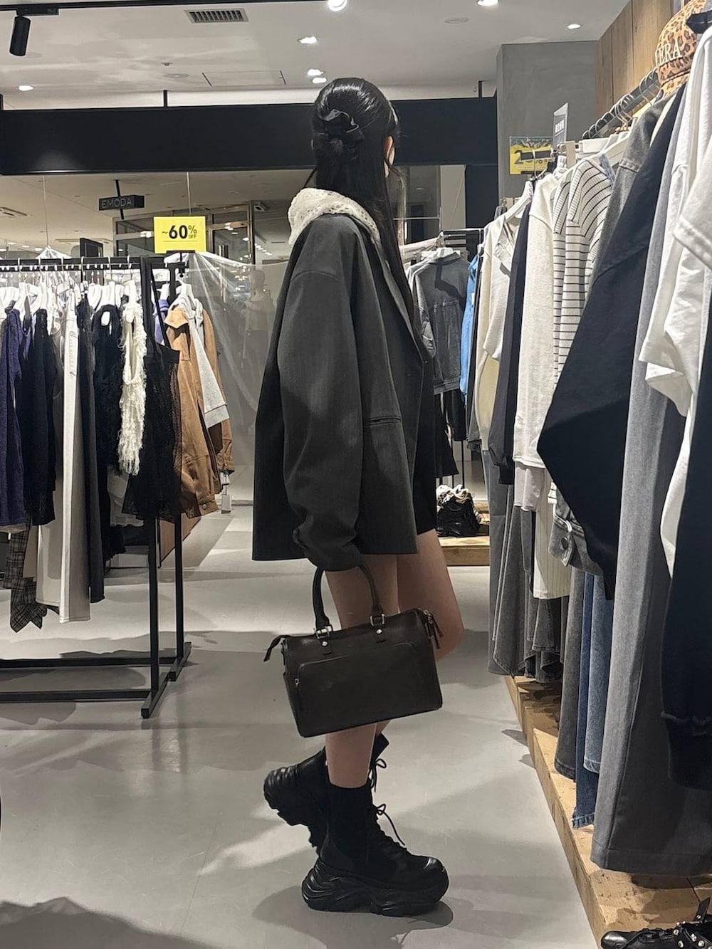 ブラック系のブーツ、ホワイト系のパーカー、グレー系のショルダーバッグを着用したレディースの春コーディネートの5枚目の写真