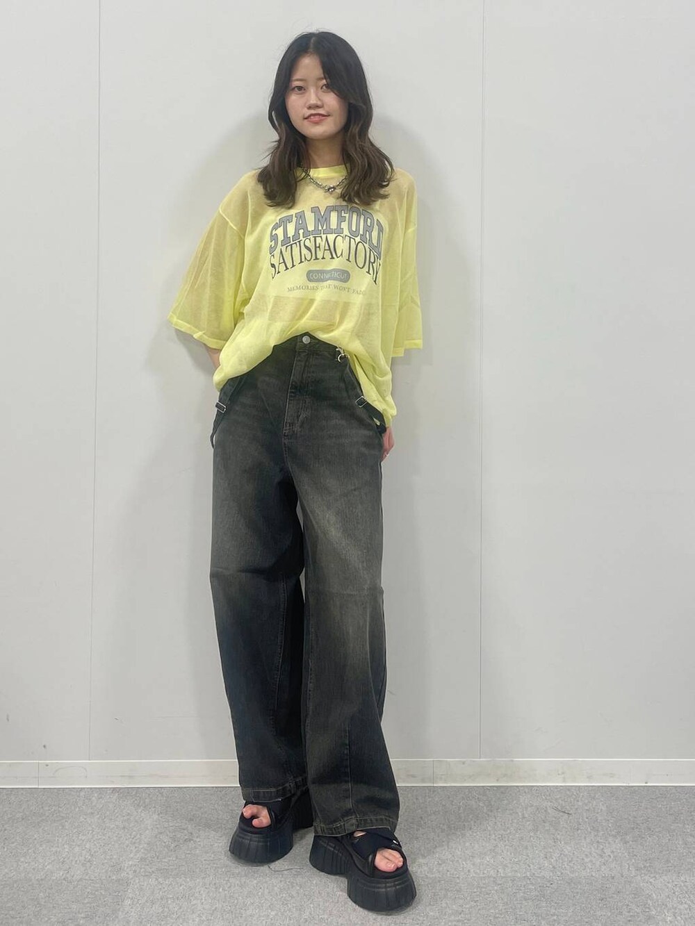 ブラック系のスニーカー、ブラック系のデニムパンツ、イエロー系のTシャツ/カットソーを着用したレディースの夏コーディネートの2枚目の写真