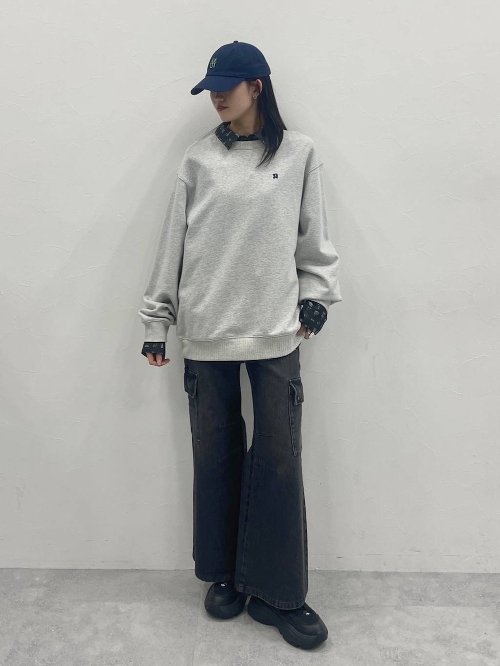 グレー系のスウェット、ブラック系のシャツ/ブラウス、ブルー系のキャップを着用したレディースの冬コーディネートの2枚目の写真