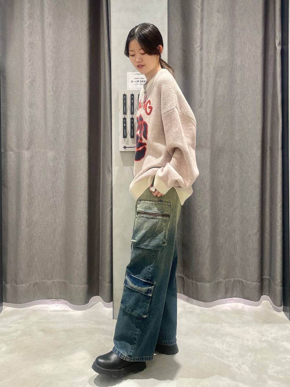 ブルー系のデニムパンツ、ベージュ系のニット/セーター、シルバー系のネックレスを着用したレディースの秋コーディネートの2枚目の写真