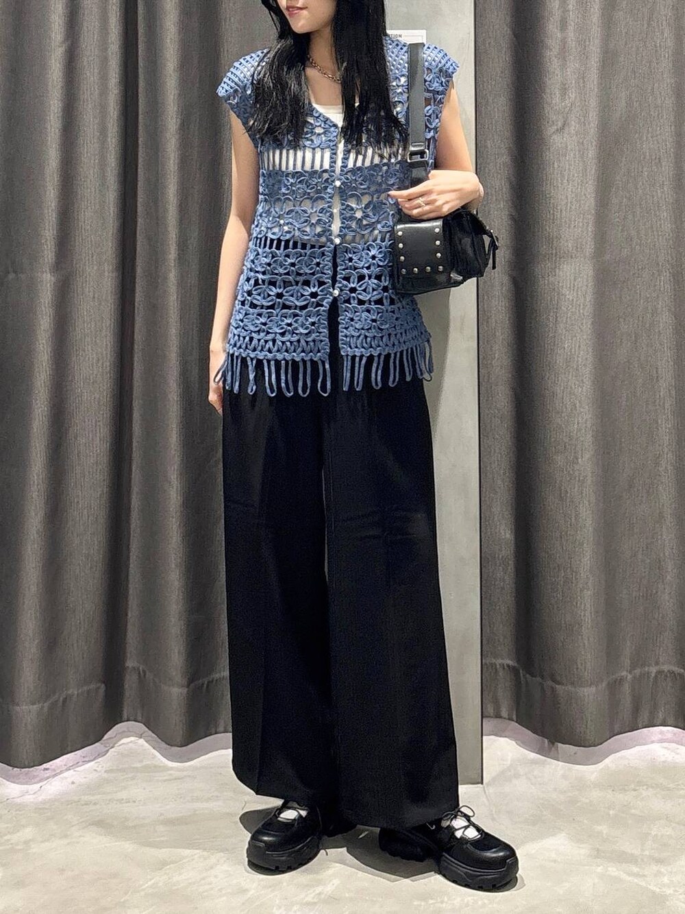 ホワイト系のタンクトップ、ブラック系のスラックス、ブルー系のベストを着用したレディースの夏コーディネートの2枚目の写真