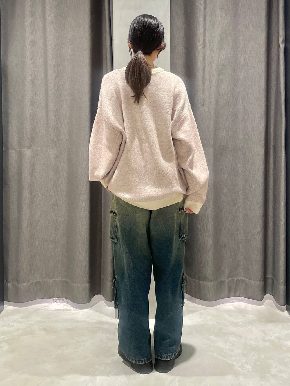 ブルー系のデニムパンツ、ベージュ系のニット/セーター、シルバー系のネックレスを着用したレディースの秋コーディネートの3枚目の写真