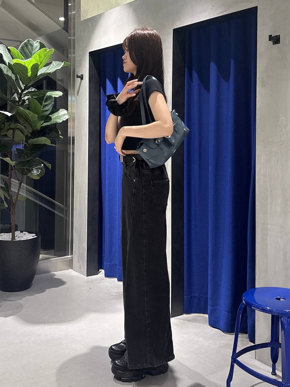 ブラック系のデニムパンツ、ブラック系のスニーカー、ブラック系のTシャツ/カットソーを着用したレディースの夏コーディネートの2枚目の写真