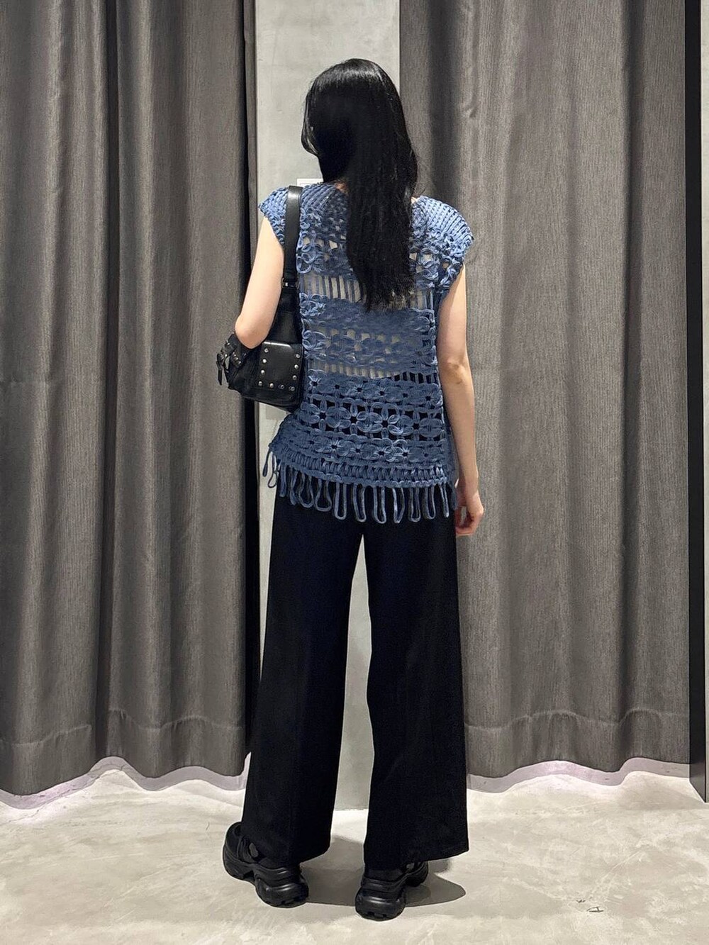 ホワイト系のタンクトップ、ブラック系のスラックス、ブルー系のベストを着用したレディースの夏コーディネートの4枚目の写真