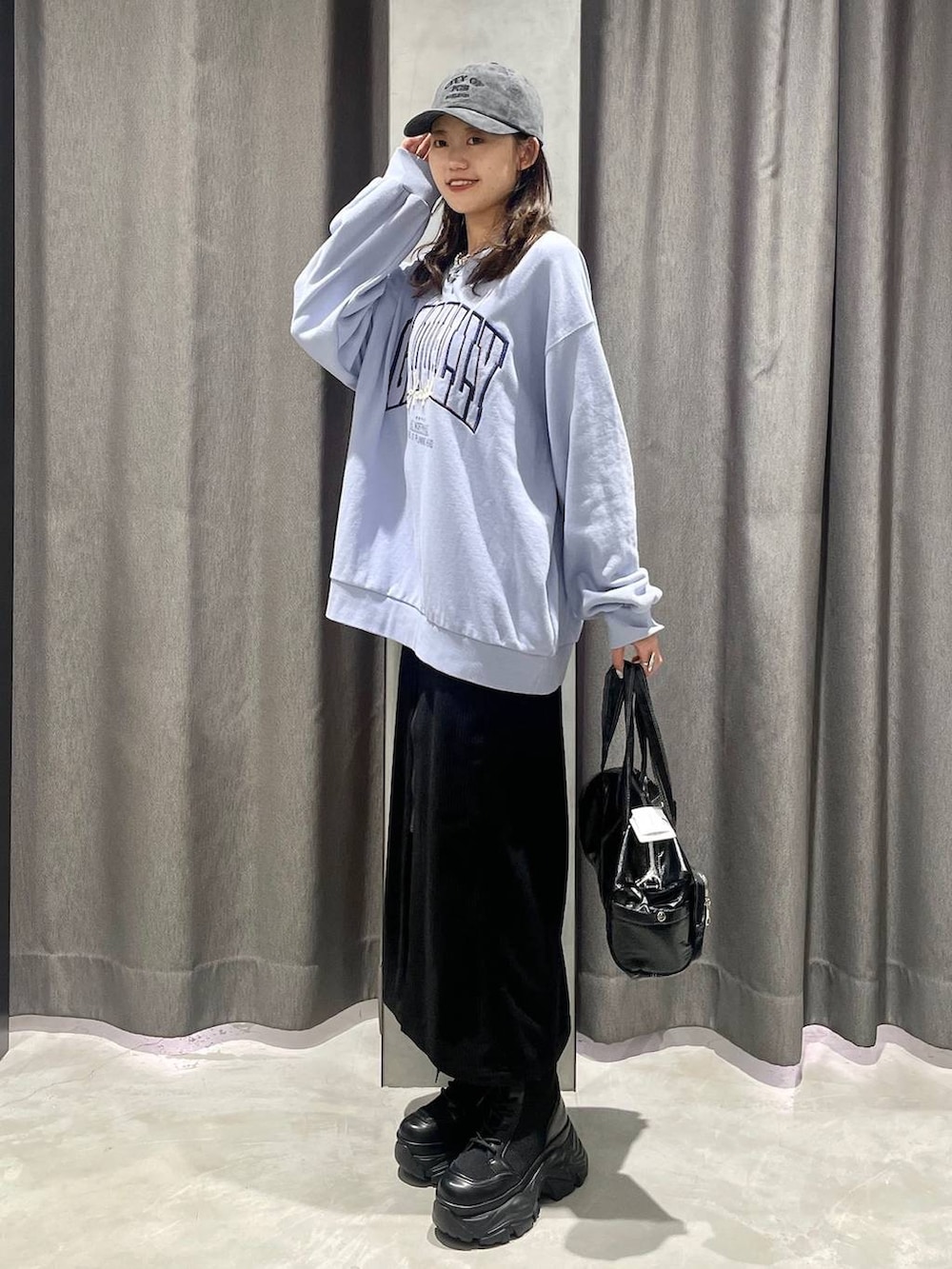 ブラウン系のブーツ、ブラック系のショルダーバッグ、ブルー系のスウェットを着用したレディースの冬コーディネートの3枚目の写真