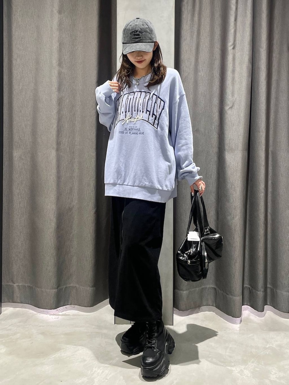 ブラウン系のブーツ、ブラック系のショルダーバッグ、ブルー系のスウェットを着用したレディースの冬コーディネートの2枚目の写真