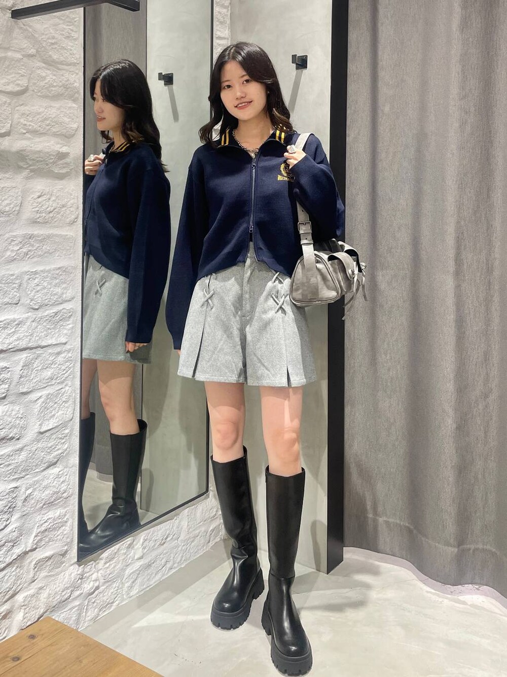 グレー系のショルダーバッグ、ブラック系のその他パンツ、ブラック系のブーツを着用したレディースの秋コーディネートの3枚目の写真