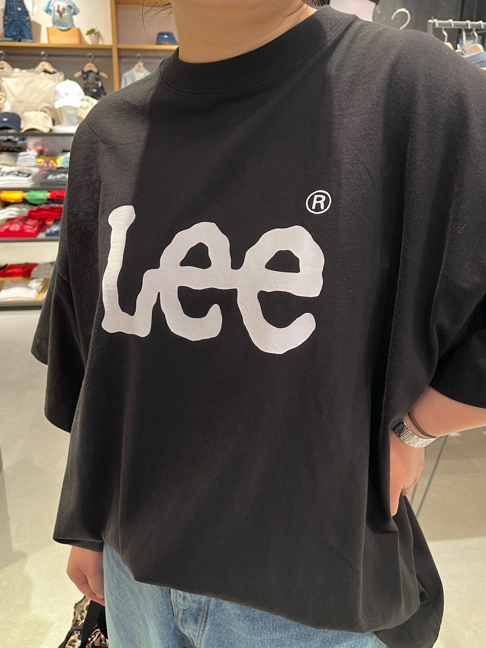 ブラック系のTシャツ/カットソー、ブルー系のデニムパンツ、その他のショルダーバッグを着用したレディースの夏コーディネートの2枚目の写真