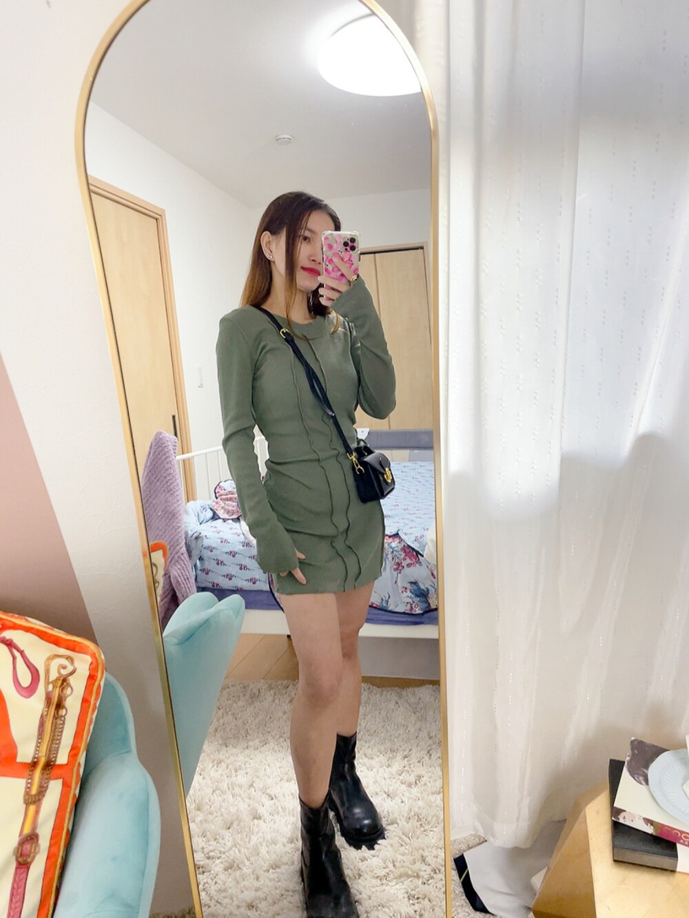 グリーン系のドレス、ブラック系のショルダーバッグ、ブラック系のブーツを着用したレディースの春コーディネートの2枚目の写真