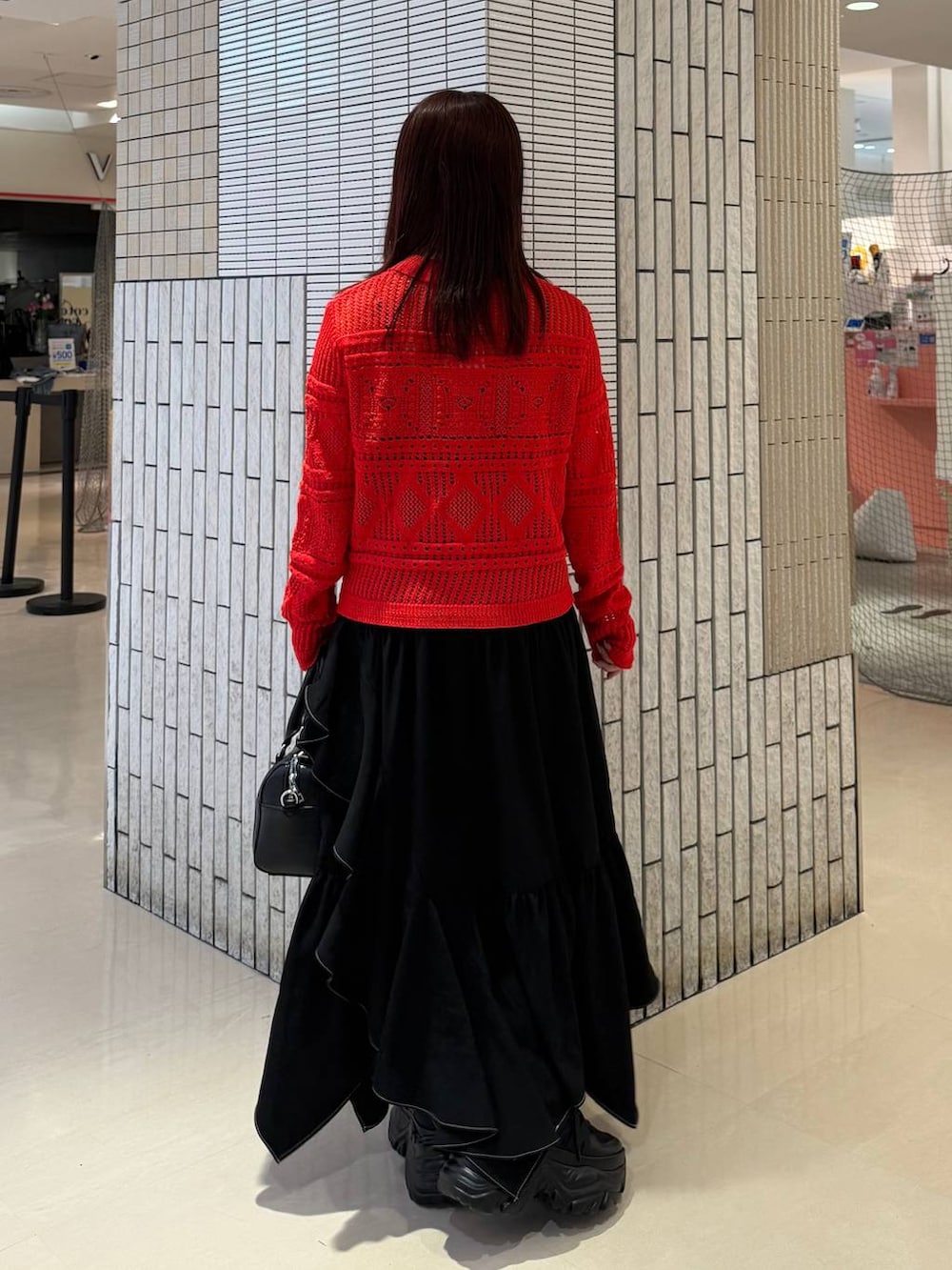 ブラック系のスニーカー、ブラック系のスカート、ブラック系のボストンバッグを着用したレディースの春コーディネートの9枚目の写真