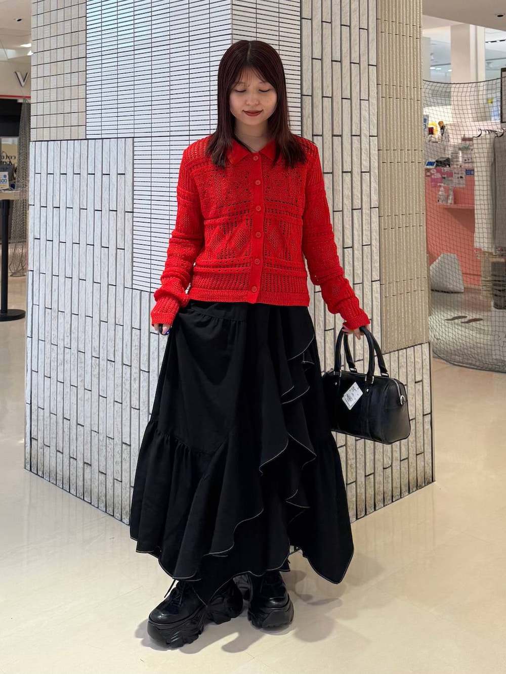 ブラック系のスニーカー、ブラック系のスカート、ブラック系のボストンバッグを着用したレディースの春コーディネートの3枚目の写真