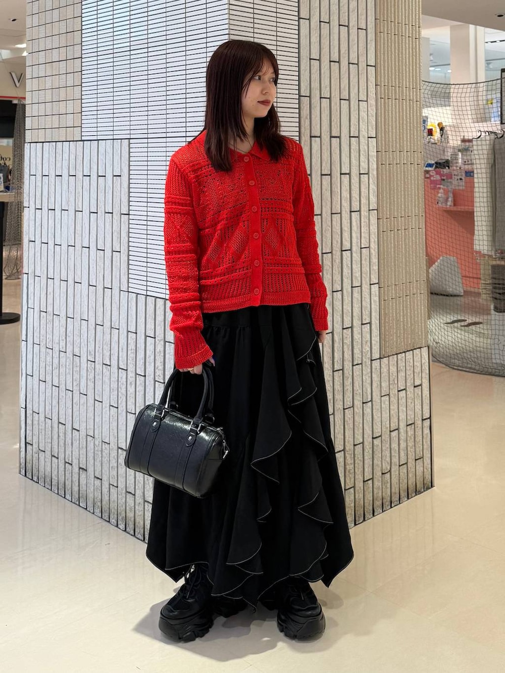 ブラック系のスニーカー、ブラック系のスカート、ブラック系のボストンバッグを着用したレディースの春コーディネートの7枚目の写真