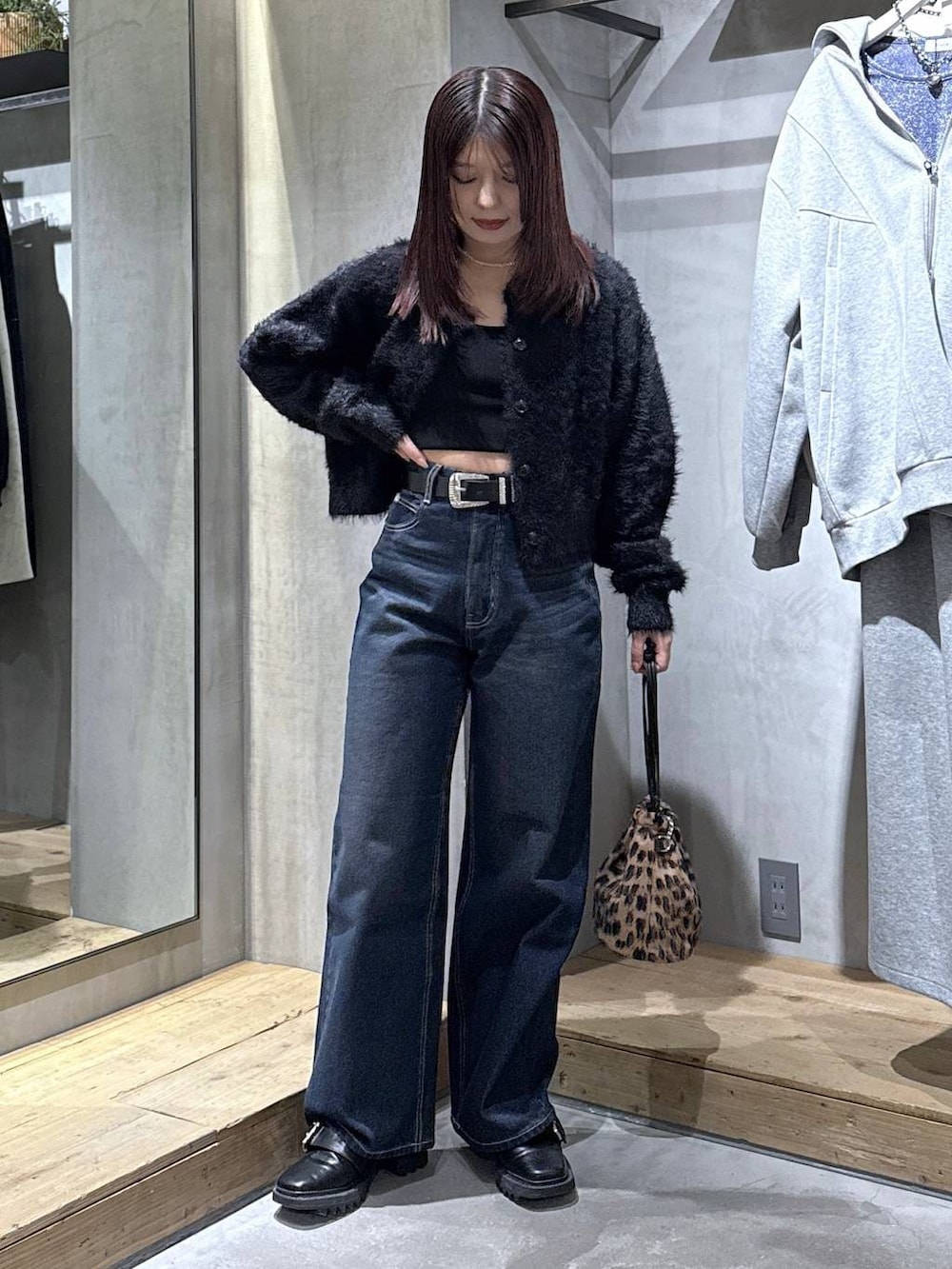 ブラック系のキャミソール、ブラック系のブーツ、その他のハンドバッグを着用したレディースの冬コーディネートの2枚目の写真