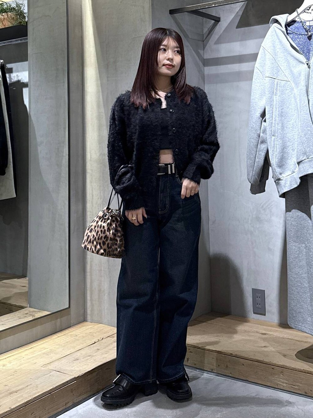 ブラック系のキャミソール、ブラック系のブーツ、その他のハンドバッグを着用したレディースの冬コーディネートの7枚目の写真