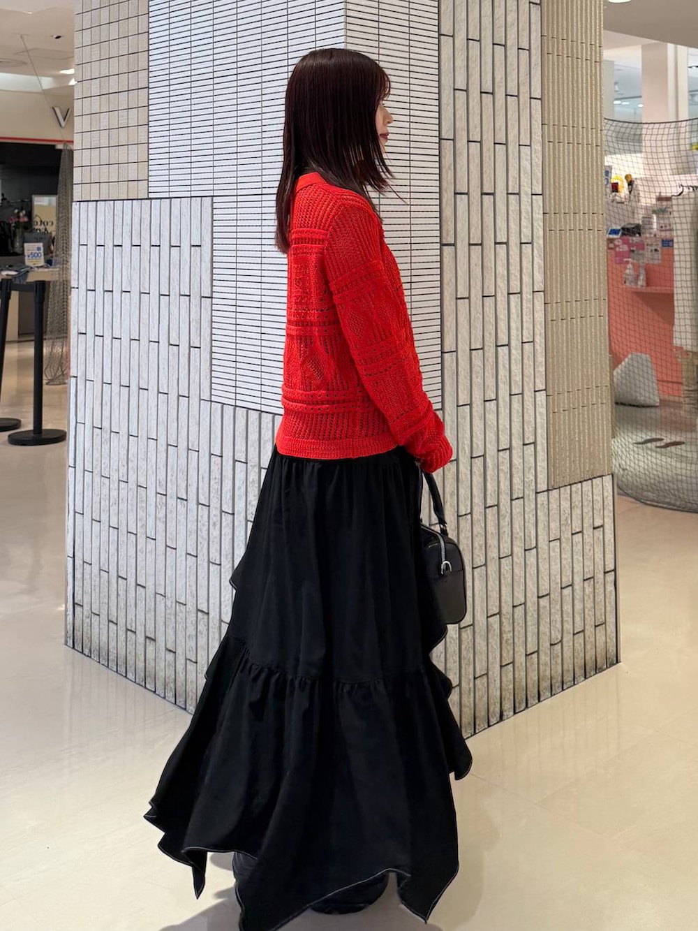 ブラック系のスニーカー、ブラック系のスカート、ブラック系のボストンバッグを着用したレディースの春コーディネートの8枚目の写真