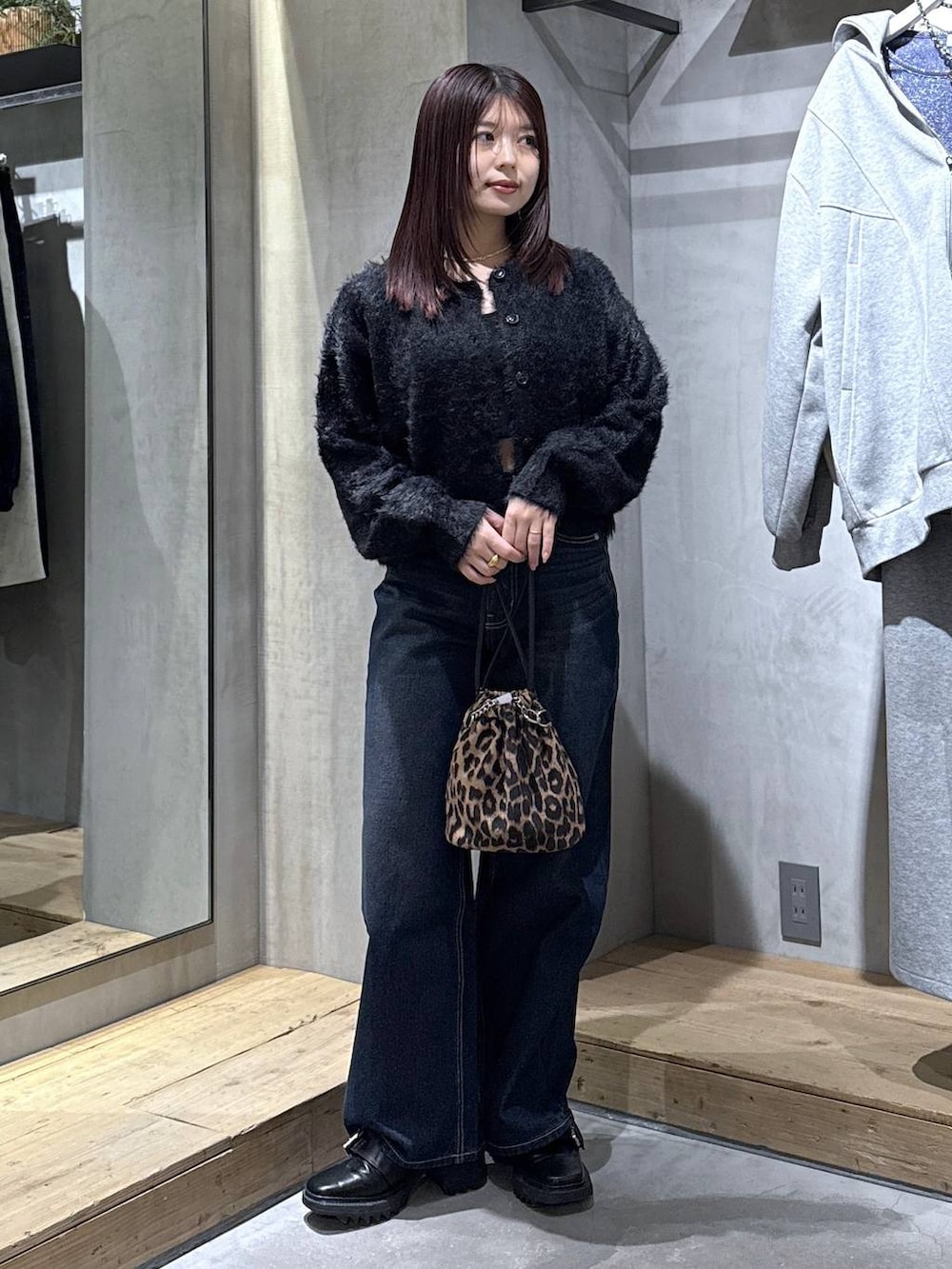 ブラック系のキャミソール、ブラック系のブーツ、その他のハンドバッグを着用したレディースの冬コーディネートの4枚目の写真