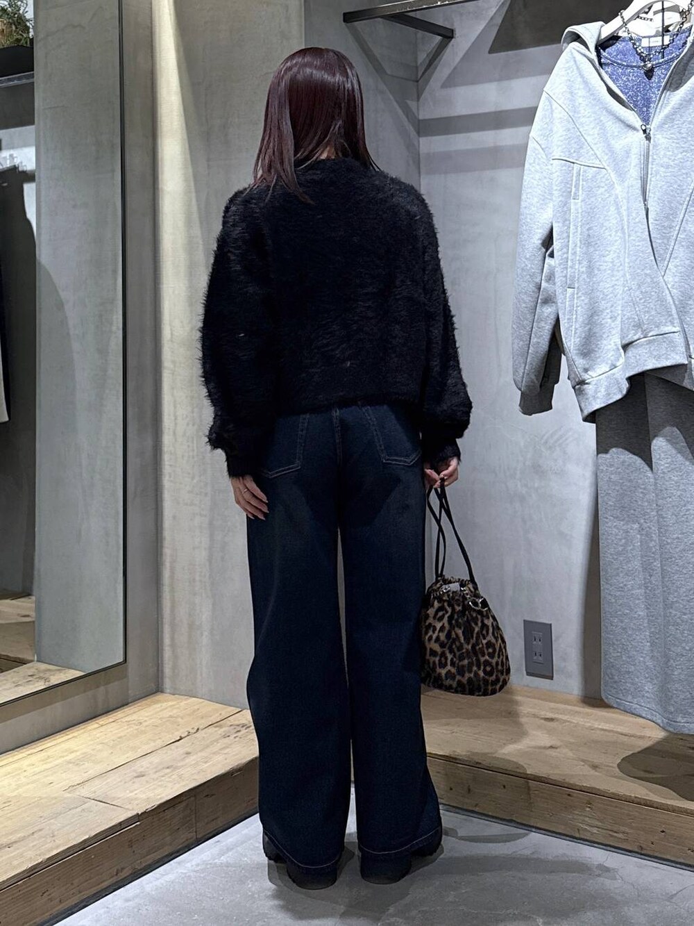 ブラック系のキャミソール、ブラック系のブーツ、その他のハンドバッグを着用したレディースの冬コーディネートの9枚目の写真