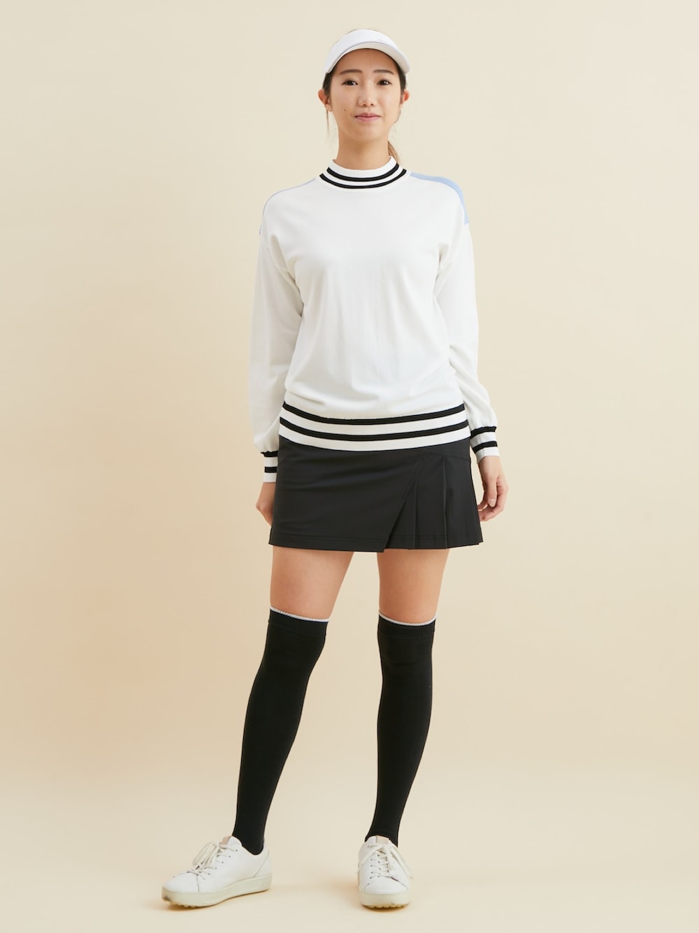 ホワイト系のニット/セーター、ブラック系のスカートを着用したレディースの冬コーディネートの2枚目の写真