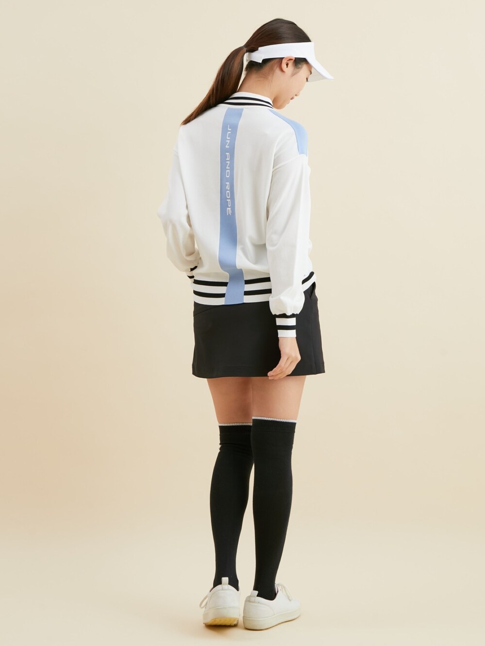 ホワイト系のニット/セーター、ブラック系のスカートを着用したレディースの冬コーディネートの3枚目の写真