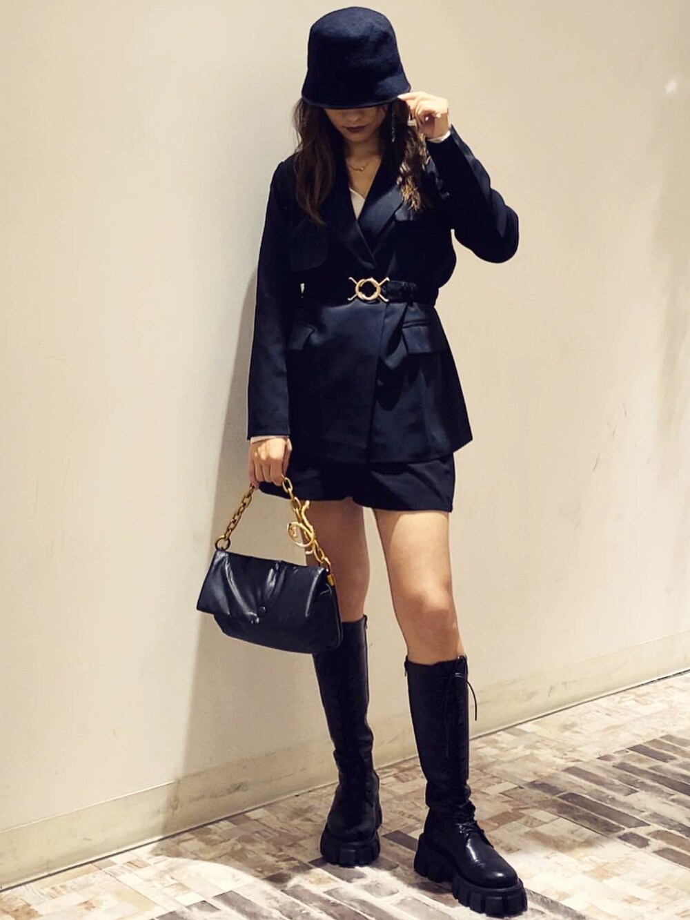 ブラック系のテーラードジャケット、ブラック系のハットを着用したレディースの冬コーディネートの2枚目の写真