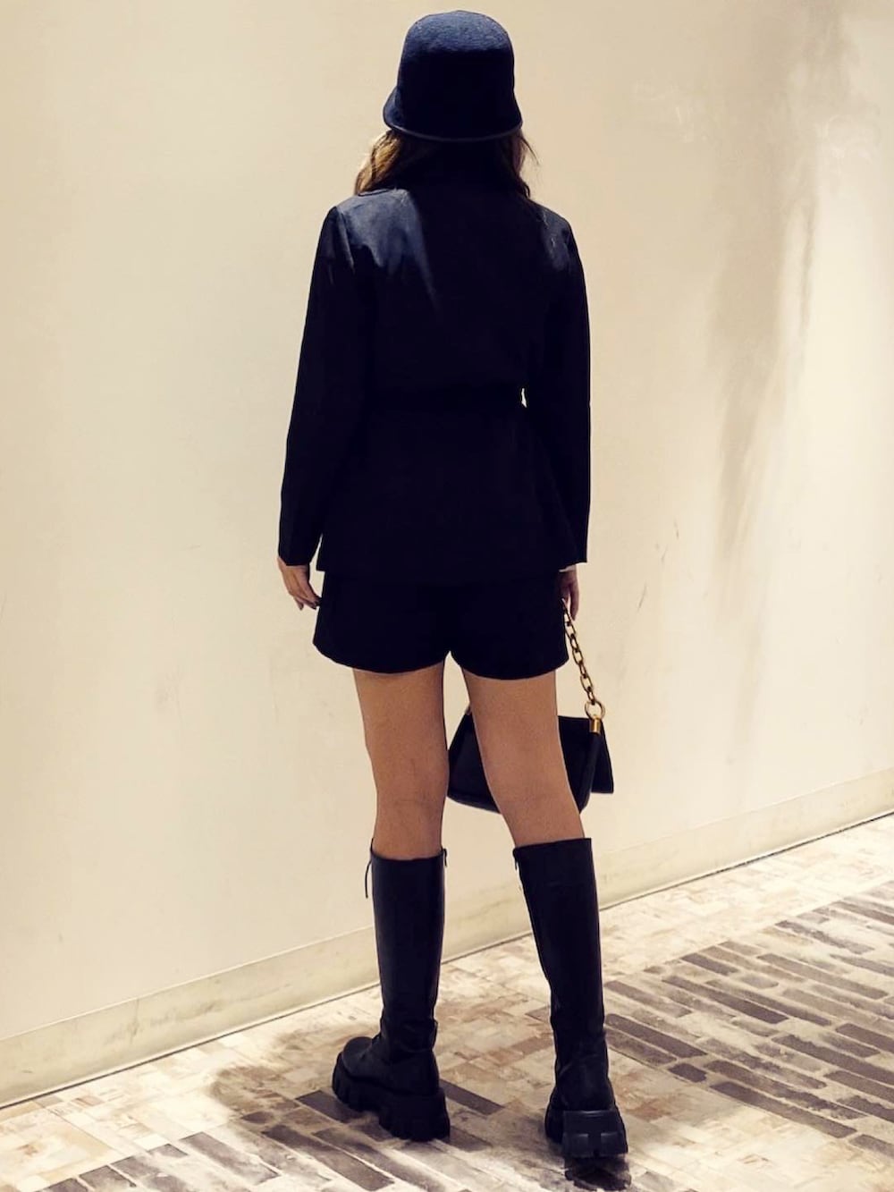 ブラック系のテーラードジャケット、ブラック系のハットを着用したレディースの冬コーディネートの4枚目の写真