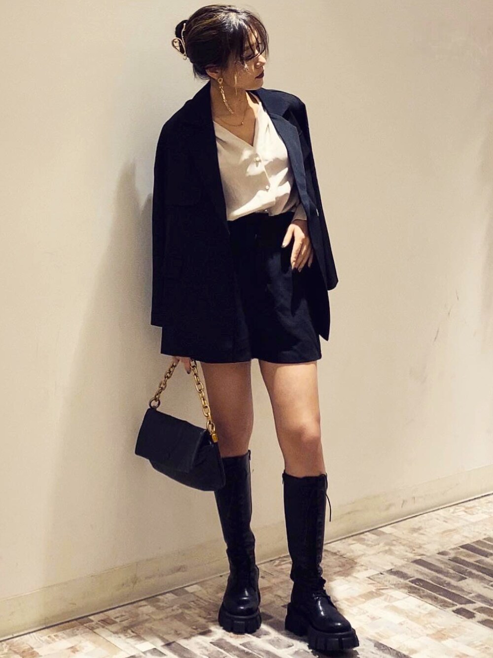 ブラック系のテーラードジャケット、ブラック系のハットを着用したレディースの冬コーディネートの3枚目の写真