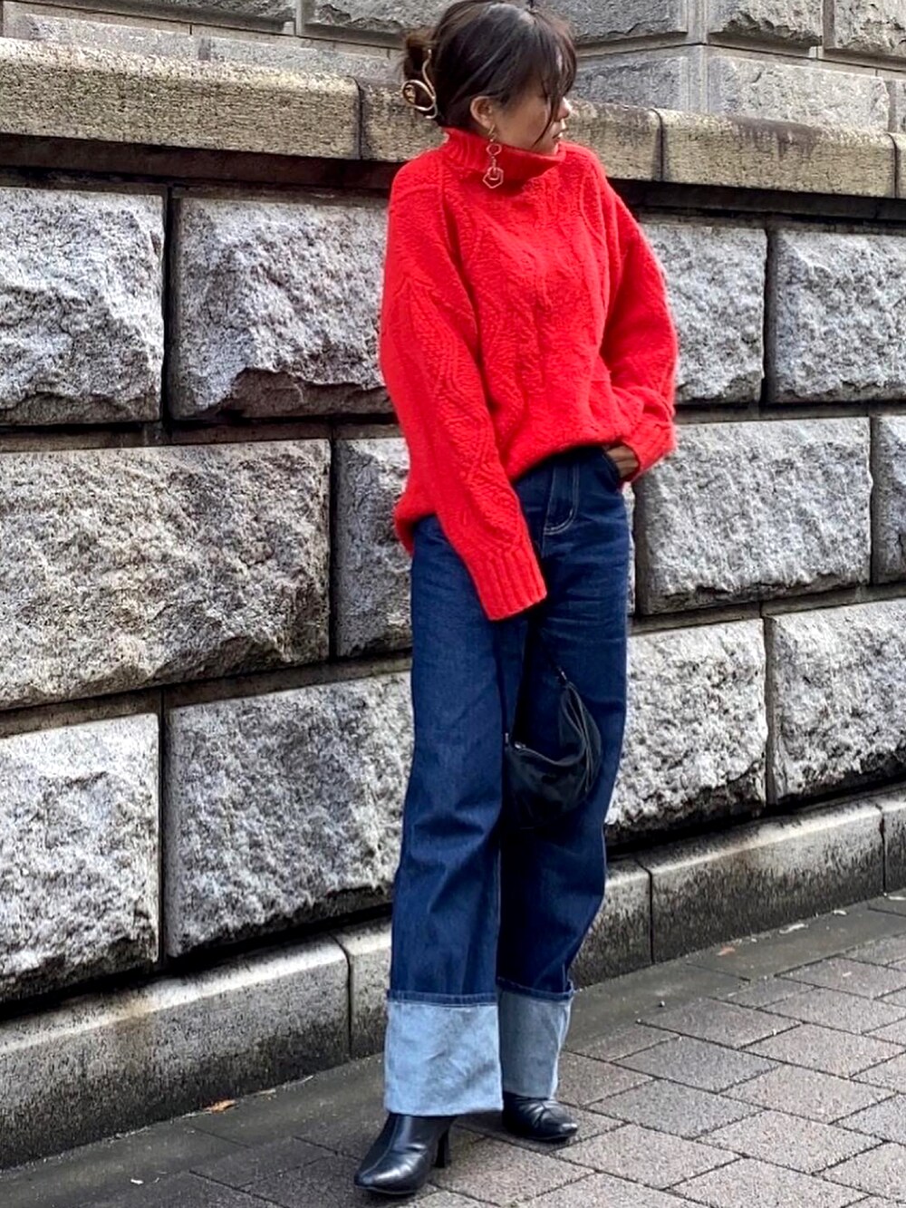 レッド系のニット/セーターを着用したレディースの冬コーディネートの2枚目の写真