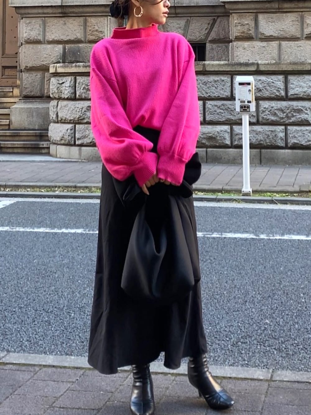 ブラック系のスカート、ピンク系のニット/セーターを着用したレディースの冬コーディネートの2枚目の写真