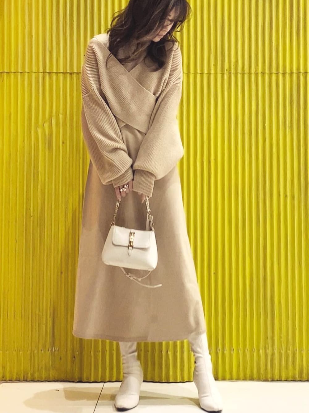 ベージュ系のワンピースを着用したレディースの冬コーディネートの2枚目の写真