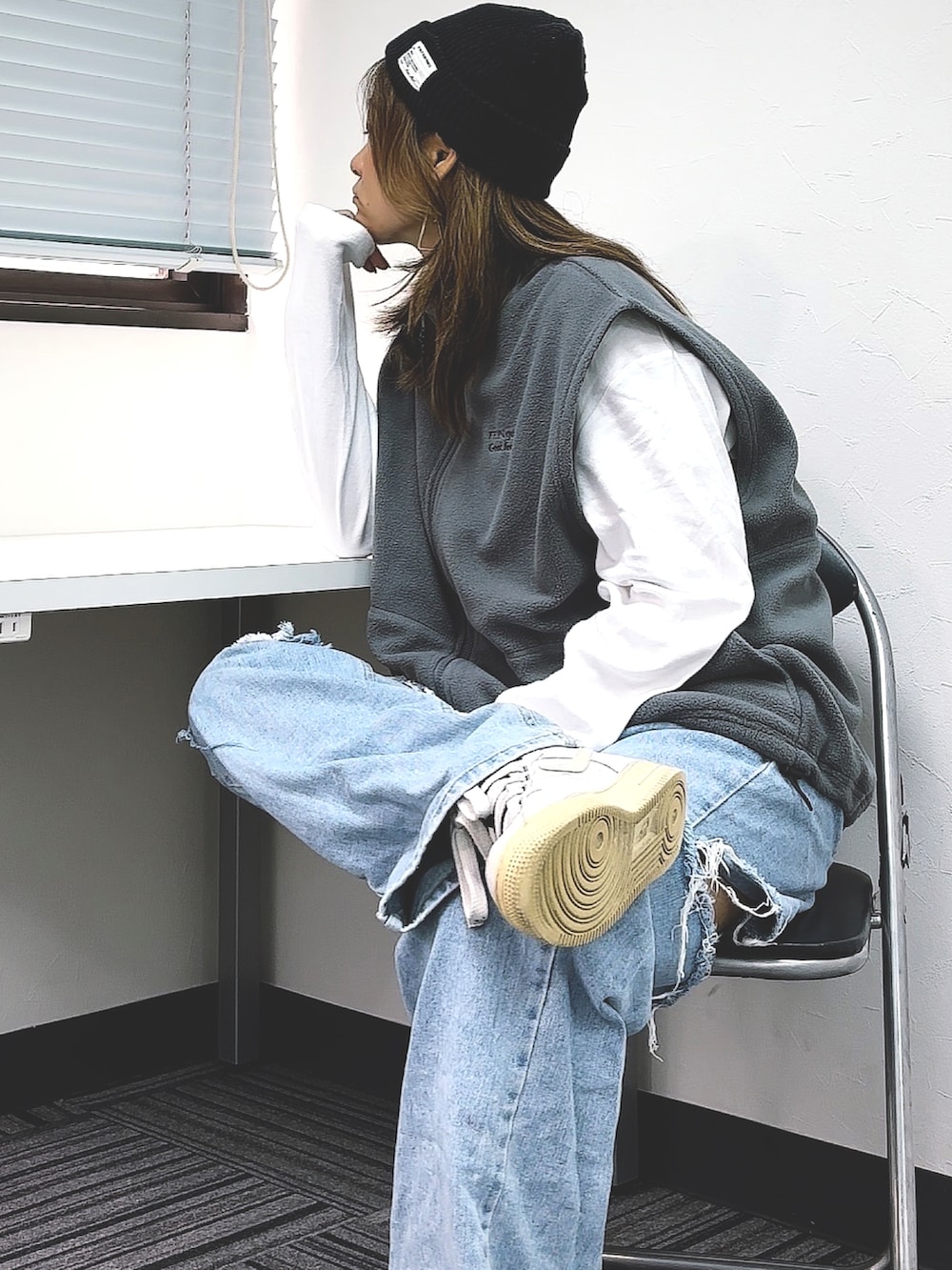 グレー系のベストを着用したレディースの秋コーディネートの2枚目の写真