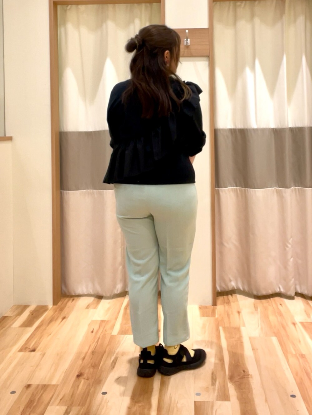 ブラック系のTシャツ/カットソー、グリーン系のパンツを着用したレディースの春コーディネートの4枚目の写真