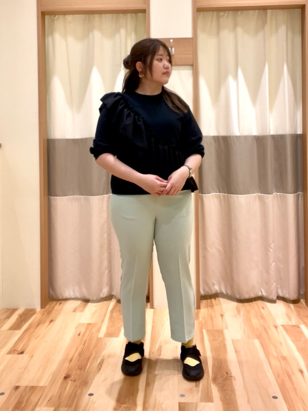 ブラック系のTシャツ/カットソー、グリーン系のパンツを着用したレディースの春コーディネートの2枚目の写真