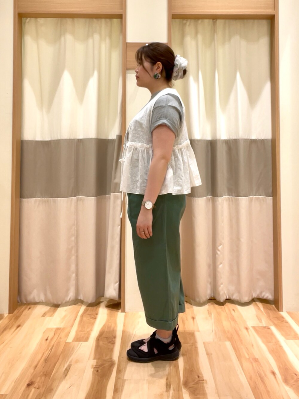 グレー系のTシャツ/カットソー、グリーン系のその他パンツ、ホワイト系のベストを着用したレディースの春コーディネートの2枚目の写真