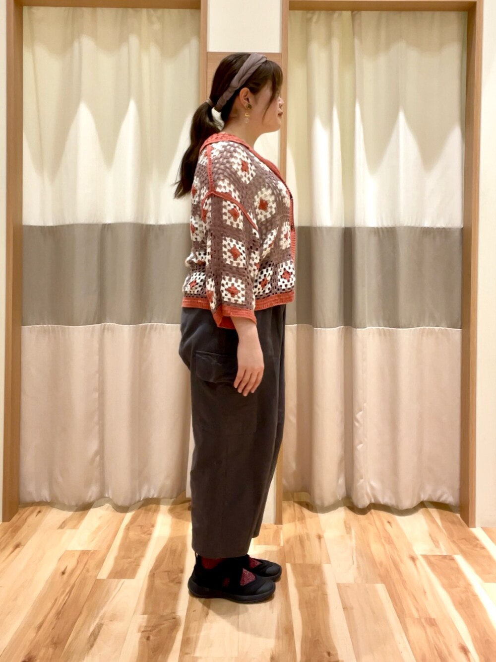 グレー系のカーゴパンツ、オレンジ系のカーディガン/ボレロを着用したレディースの春コーディネートの2枚目の写真