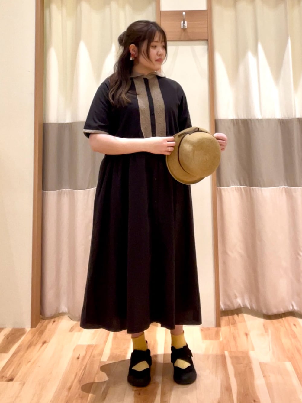 ブラウン系のワンピース、ベージュ系のハットを着用したレディースの春コーディネートの2枚目の写真