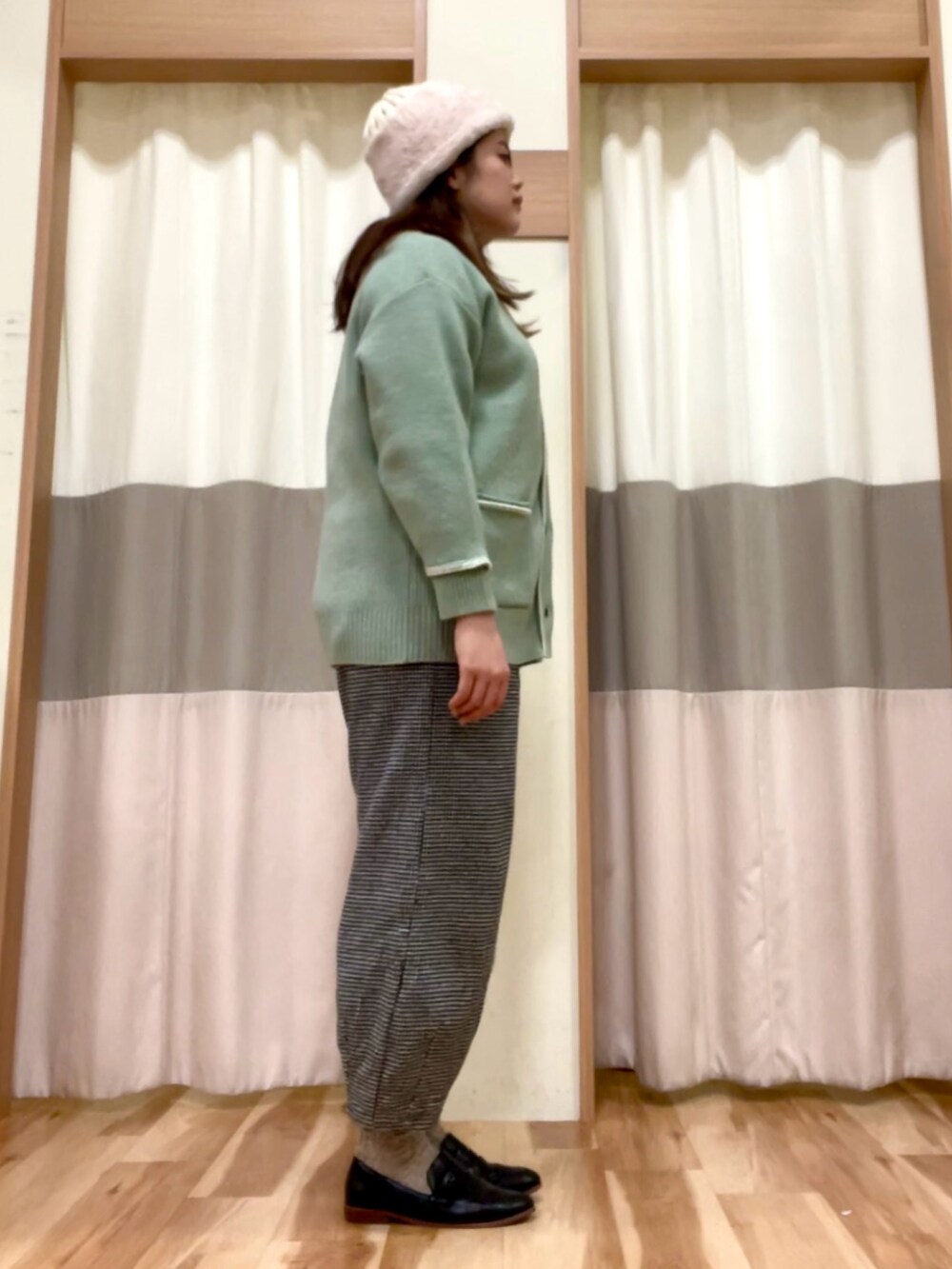 グレー系のその他パンツ、グリーン系のカーディガン/ボレロ、ホワイト系のシャツ/ブラウスを着用したレディースの冬コーディネートの2枚目の写真