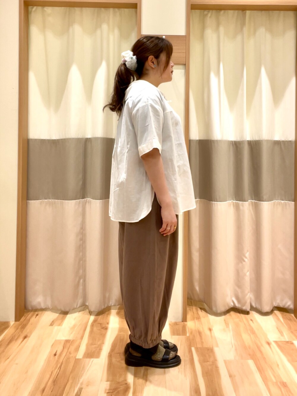 ブルー系のTシャツ/カットソー、ホワイト系のシャツ/ブラウス、ブラウン系のパンツを着用したレディースの夏コーディネートの2枚目の写真