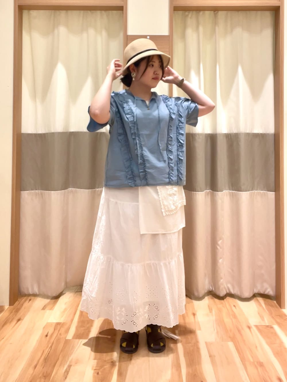 ホワイト系のスカート、ブルー系のシャツ/ブラウス、ホワイト系のTシャツ/カットソーを着用したレディースの春コーディネートの2枚目の写真