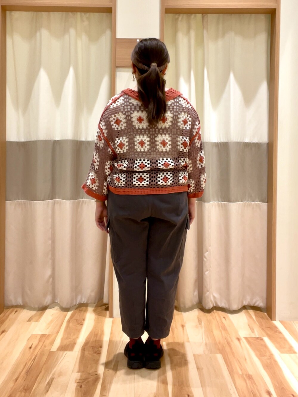 グレー系のカーゴパンツ、オレンジ系のカーディガン/ボレロを着用したレディースの春コーディネートの3枚目の写真