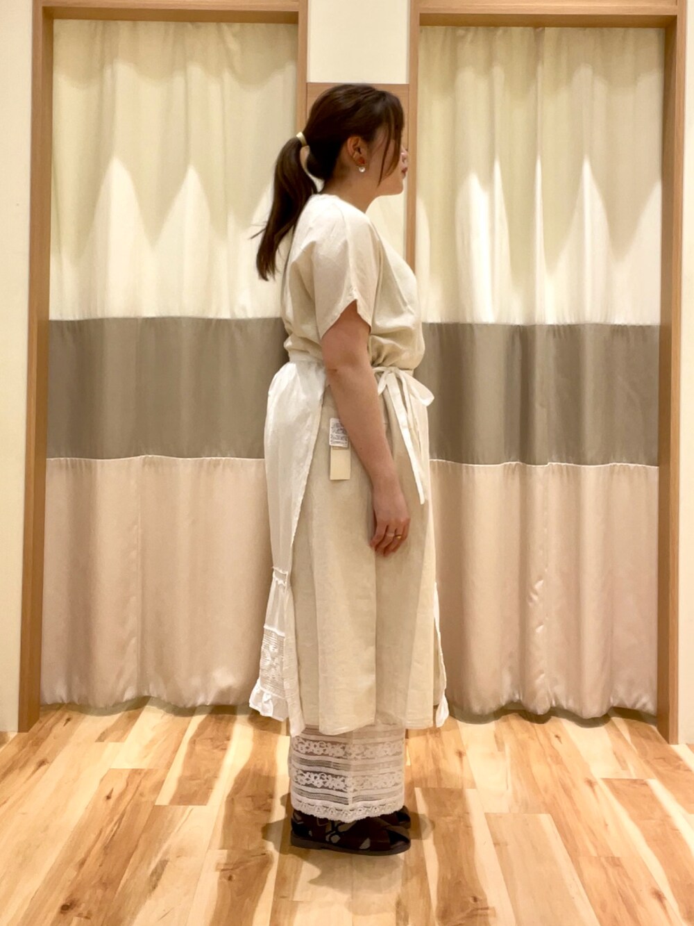 ホワイト系のワンピース、ホワイト系のパンツ、ホワイト系のエプロンを着用したレディースの春コーディネートの3枚目の写真
