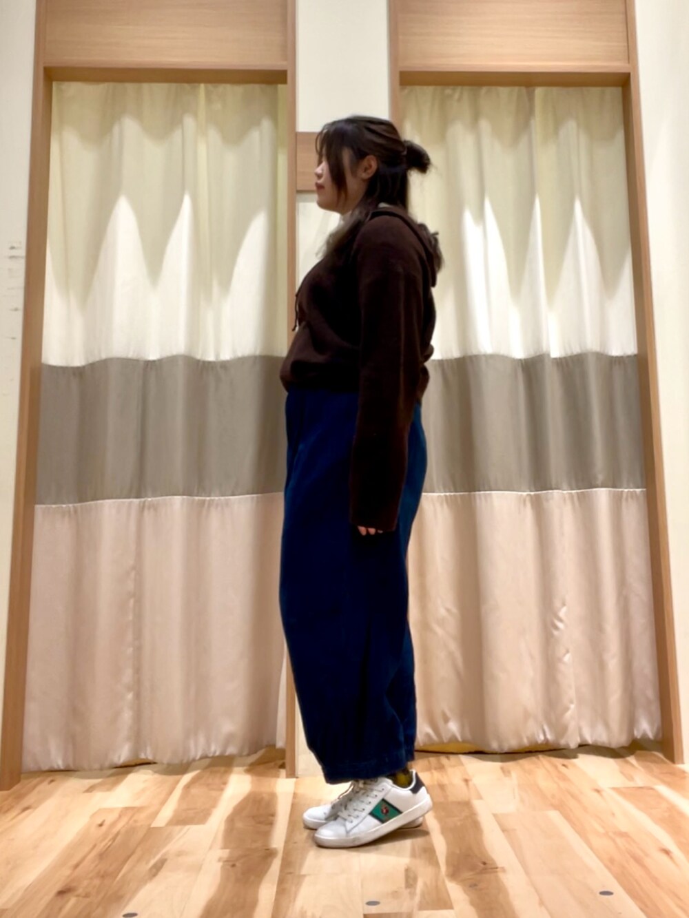 ブルー系のその他パンツ、ホワイト系のTシャツ/カットソー、ブラウン系のニット/セーターを着用したレディースの冬コーディネートの2枚目の写真
