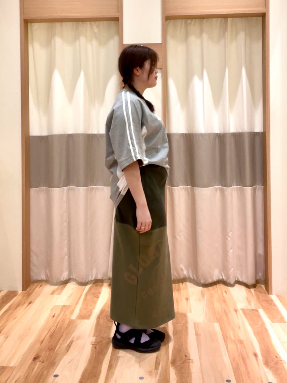 グリーン系のスカート、グレー系のTシャツ/カットソーを着用したレディースの春コーディネートの3枚目の写真