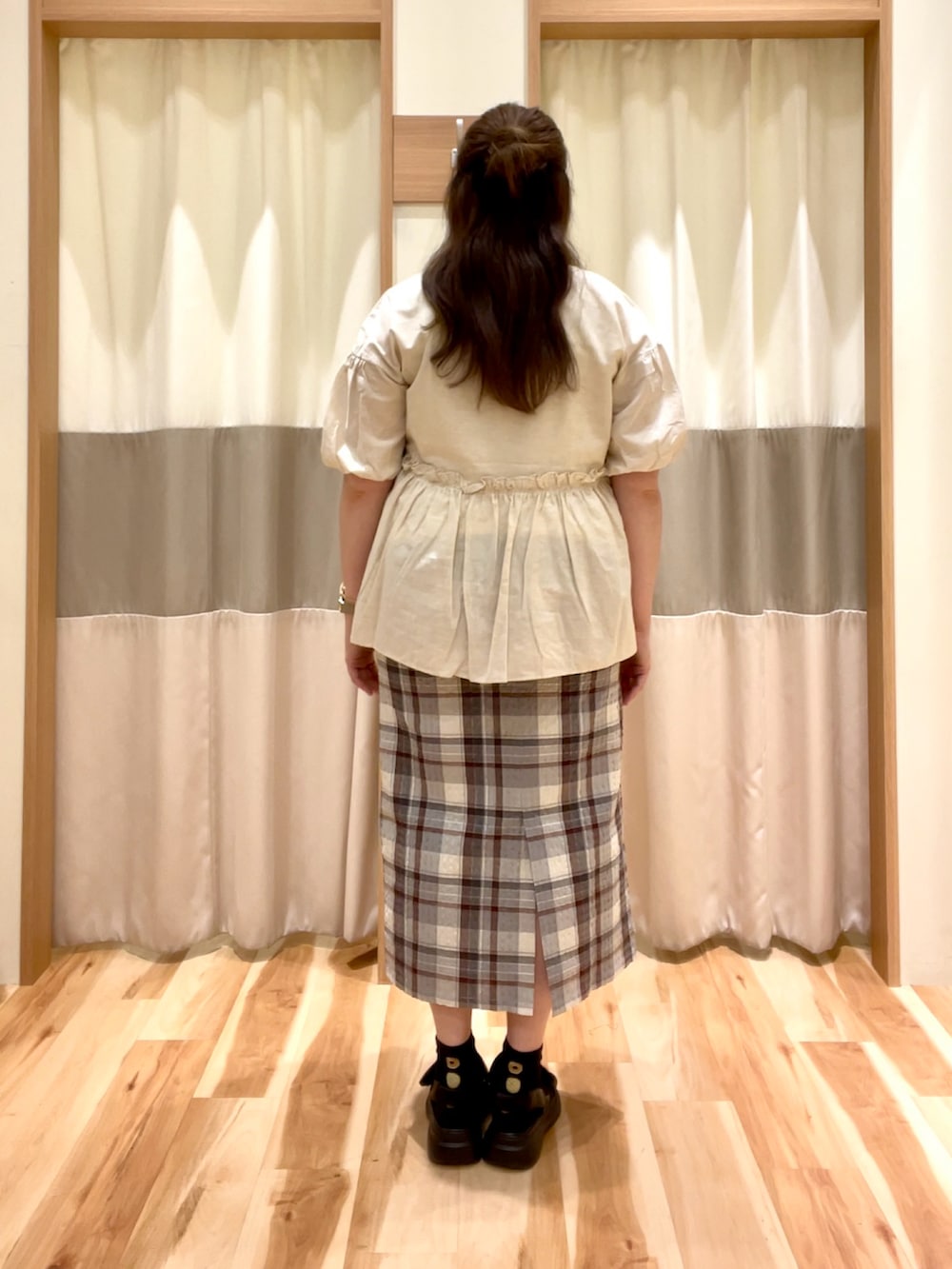 グレー系のスカート、ホワイト系のシャツ/ブラウスを着用したレディースの夏コーディネートの2枚目の写真