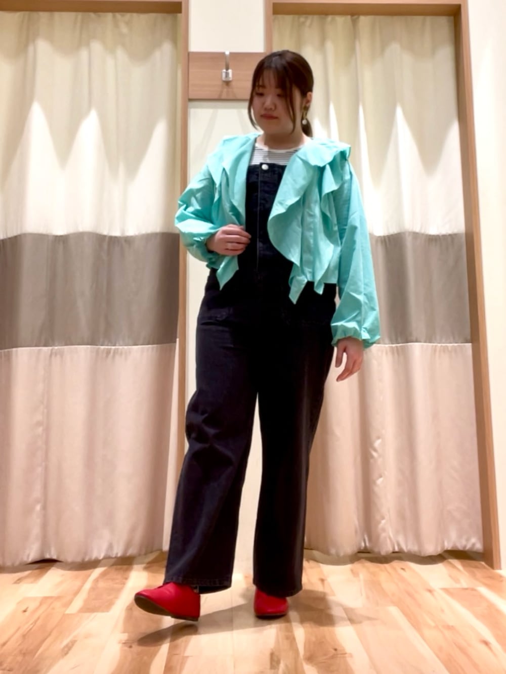 グリーン系のシャツ/ブラウス、ブラック系のオールインワン・サロペット、ブラック系のTシャツ/カットソーを着用したレディースの冬コーディネートの3枚目の写真