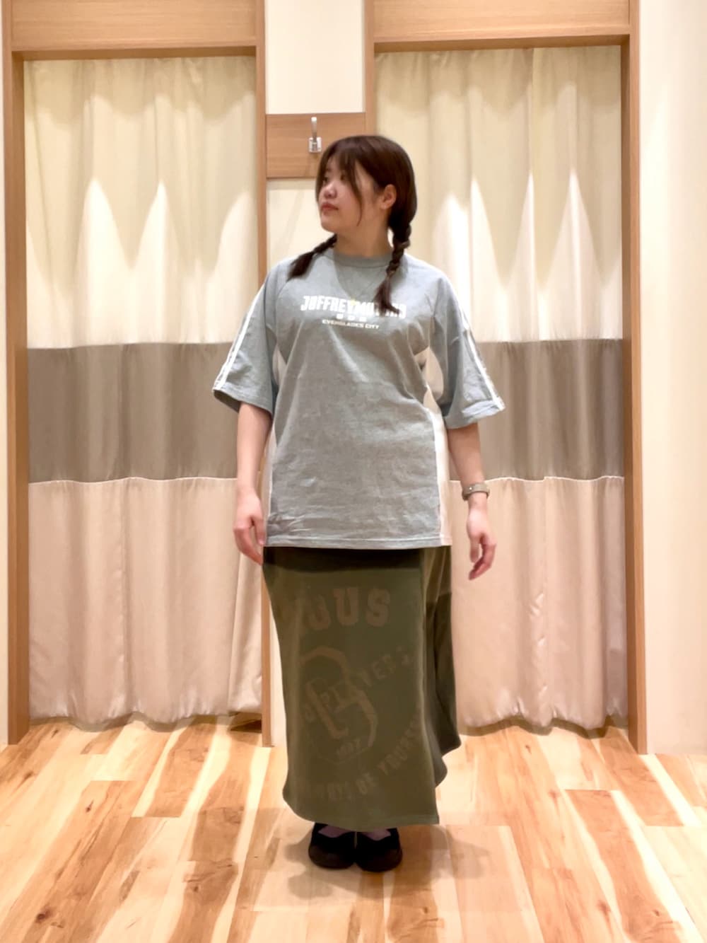 グリーン系のスカート、グレー系のTシャツ/カットソーを着用したレディースの春コーディネートの2枚目の写真